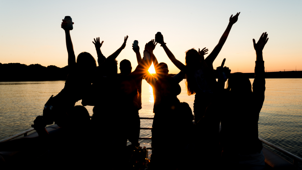 silhouette of group of people enjoying the sunset on a pontoon rental during summer in nashville