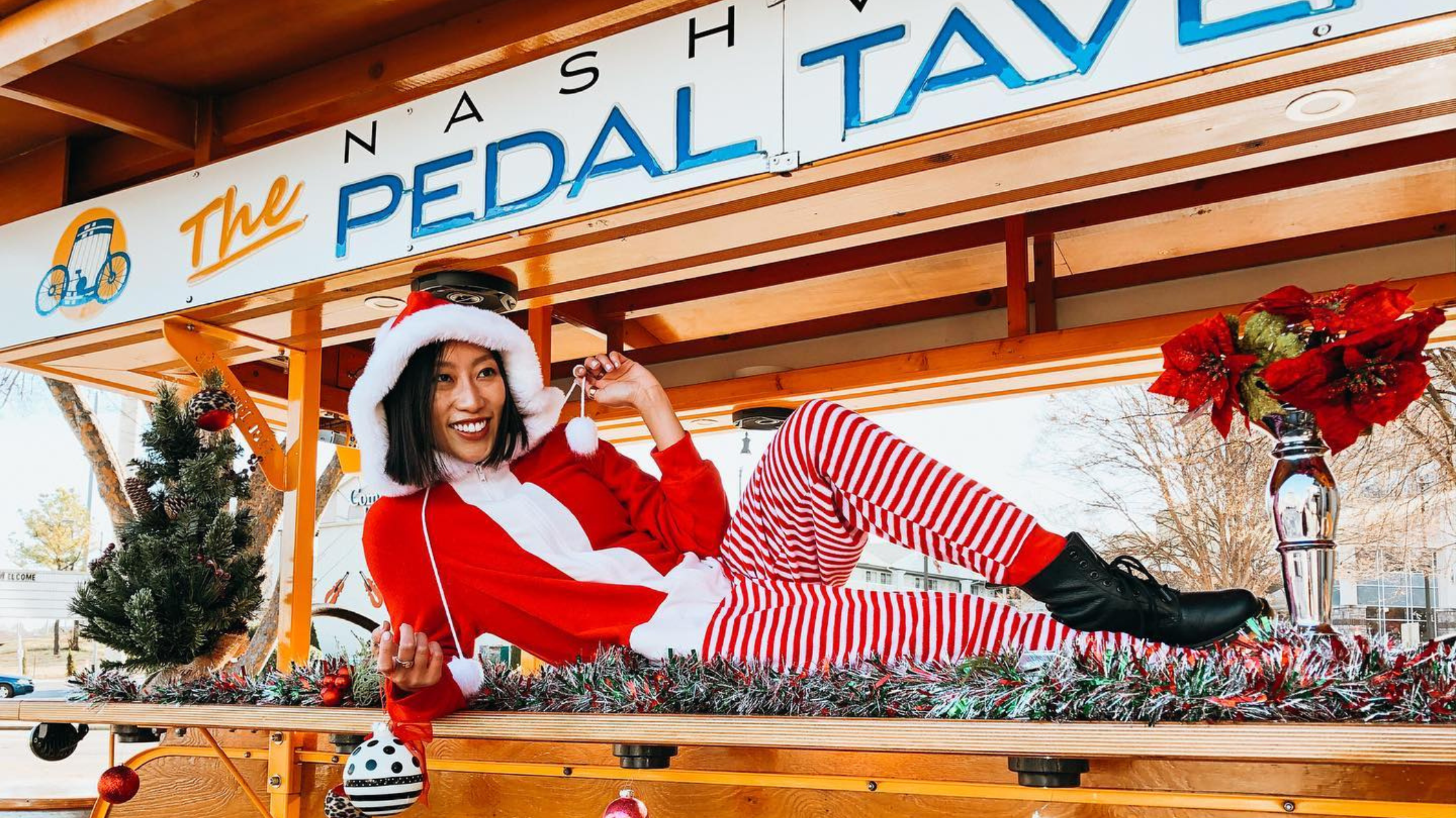 festive person sitting on top of the nashville pedal tavern bike during the christmas season